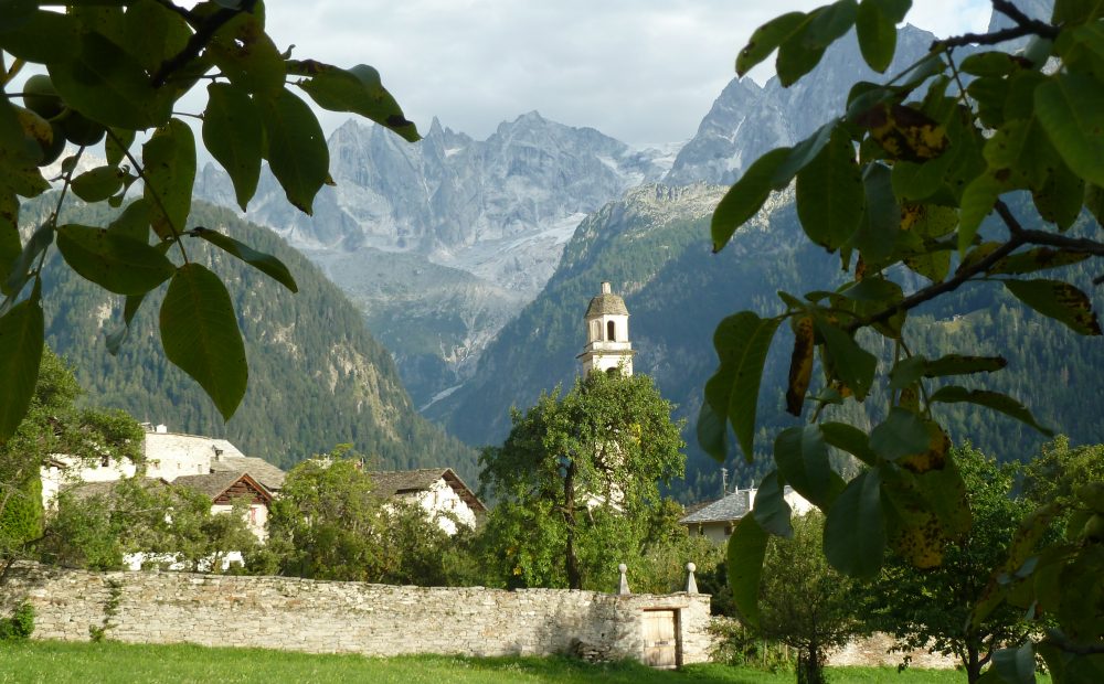 Dorf Soglio mit Wehrmauer und Kirche vor Bergkulisse