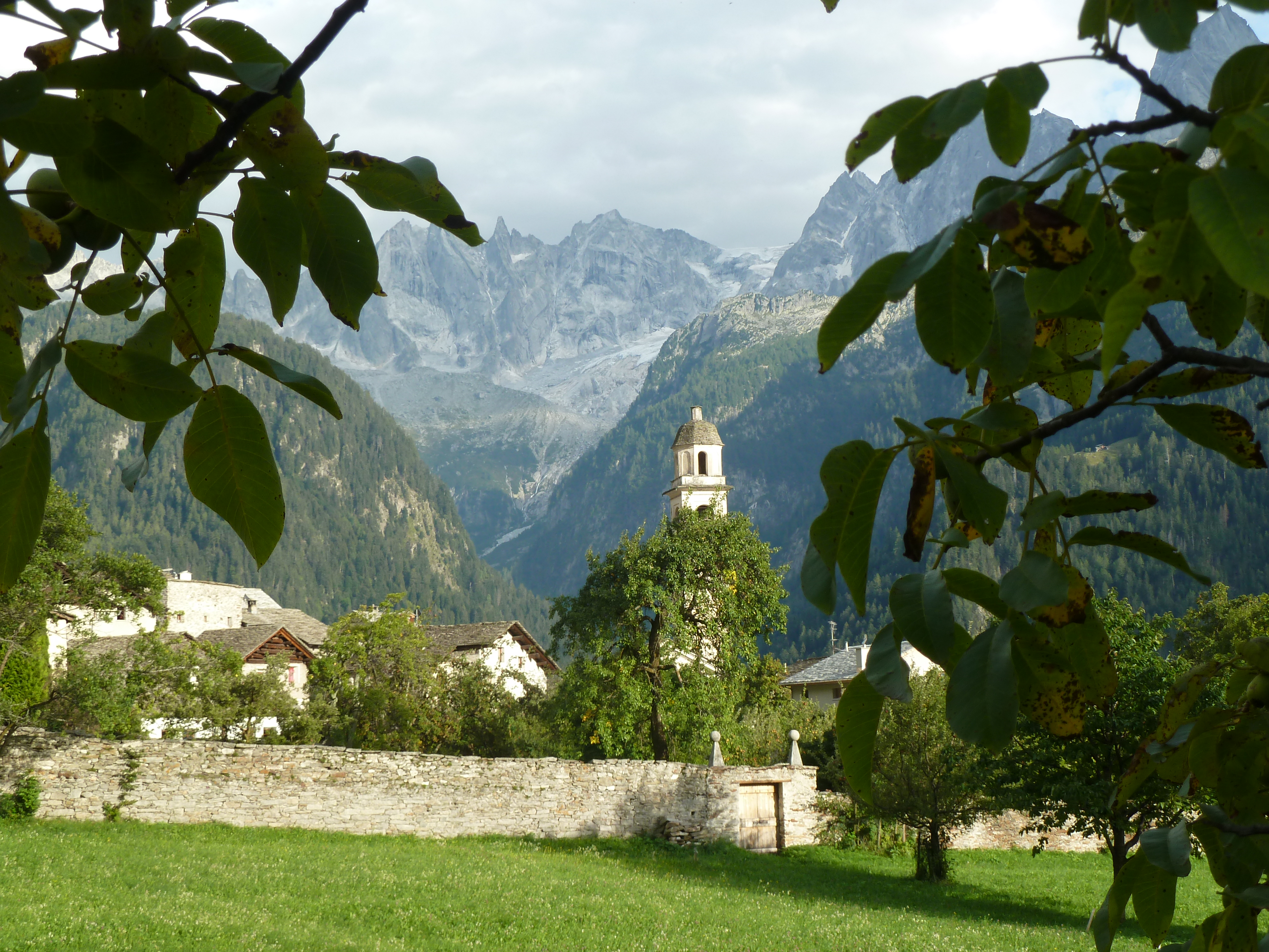 Dorf Soglio mit Wehrmauer und Kirche vor Bergkulisse